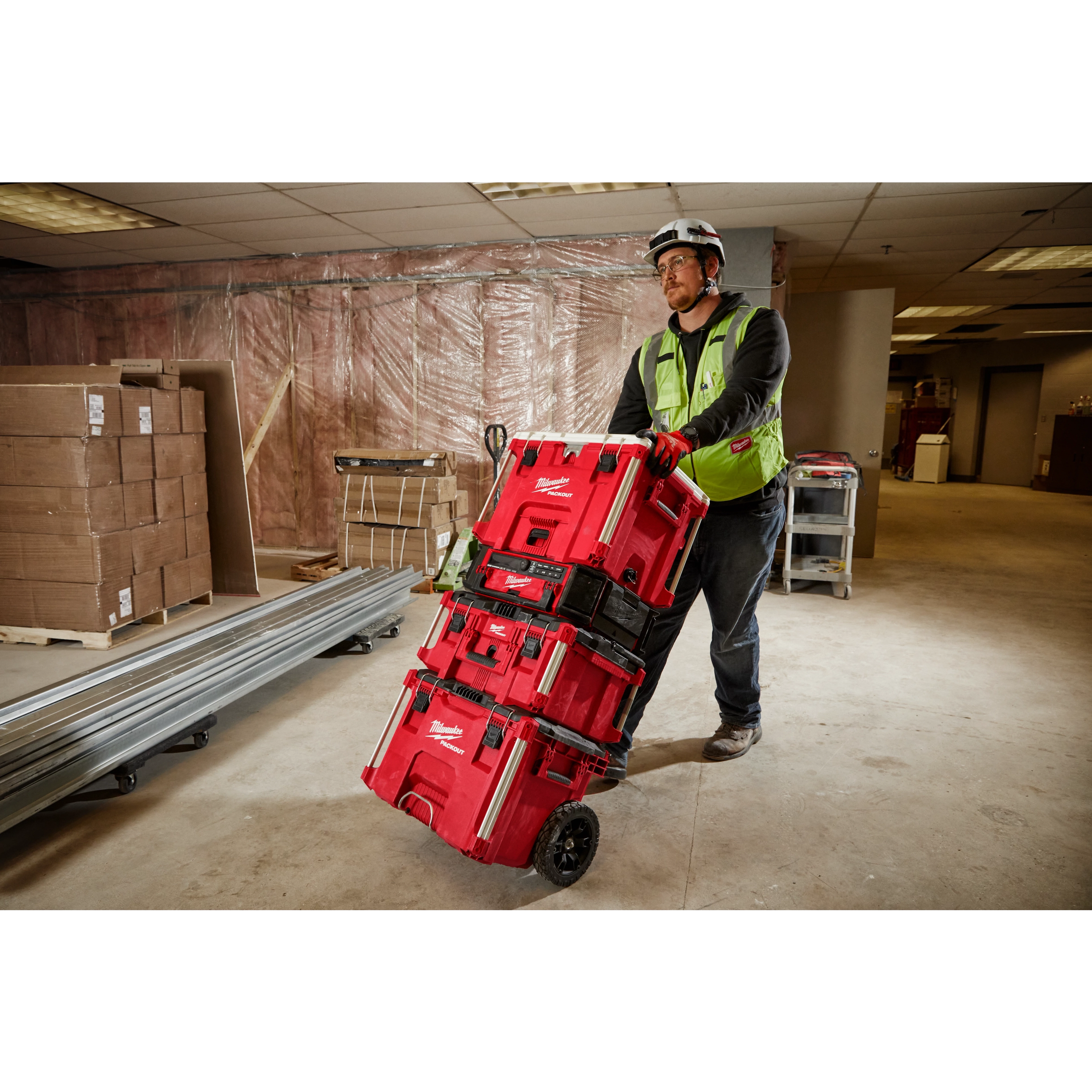 Image of a worker on a jobsite with the Milwaukee PACKOUT Rolling Tool Box and 40QT Cooler