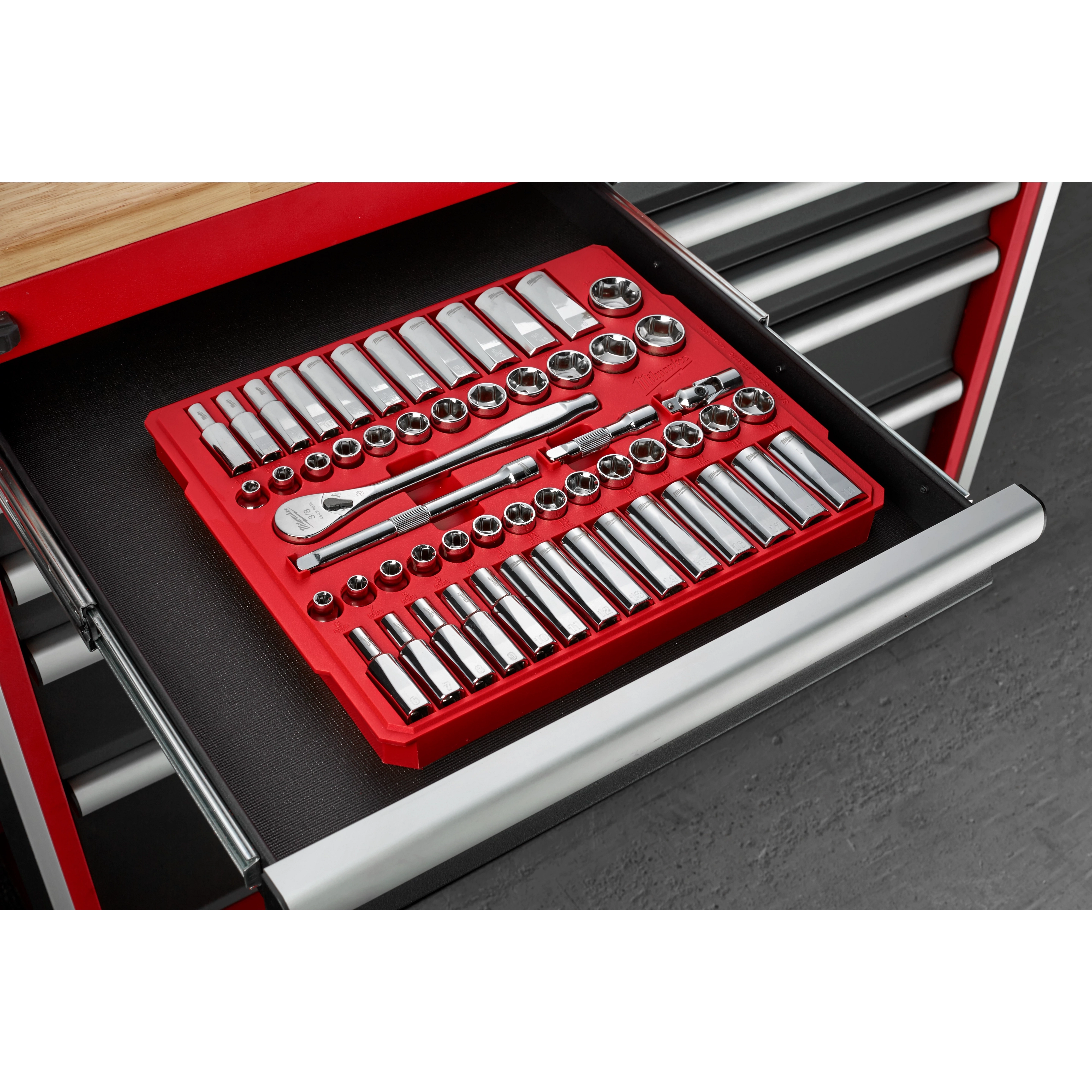 A 56-piece 3/8" Drive SAE and Metric Ratchet and Socket Set, neatly organized in a red tray, is placed inside an open drawer of a tool chest. The set includes various sizes of sockets, a ratchet, and other accessories.