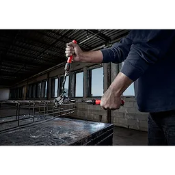 Person using the 14" Adaptable Bolt Cutter with POWERMOVE Extendable Arms to cut through metal in an industrial setting.