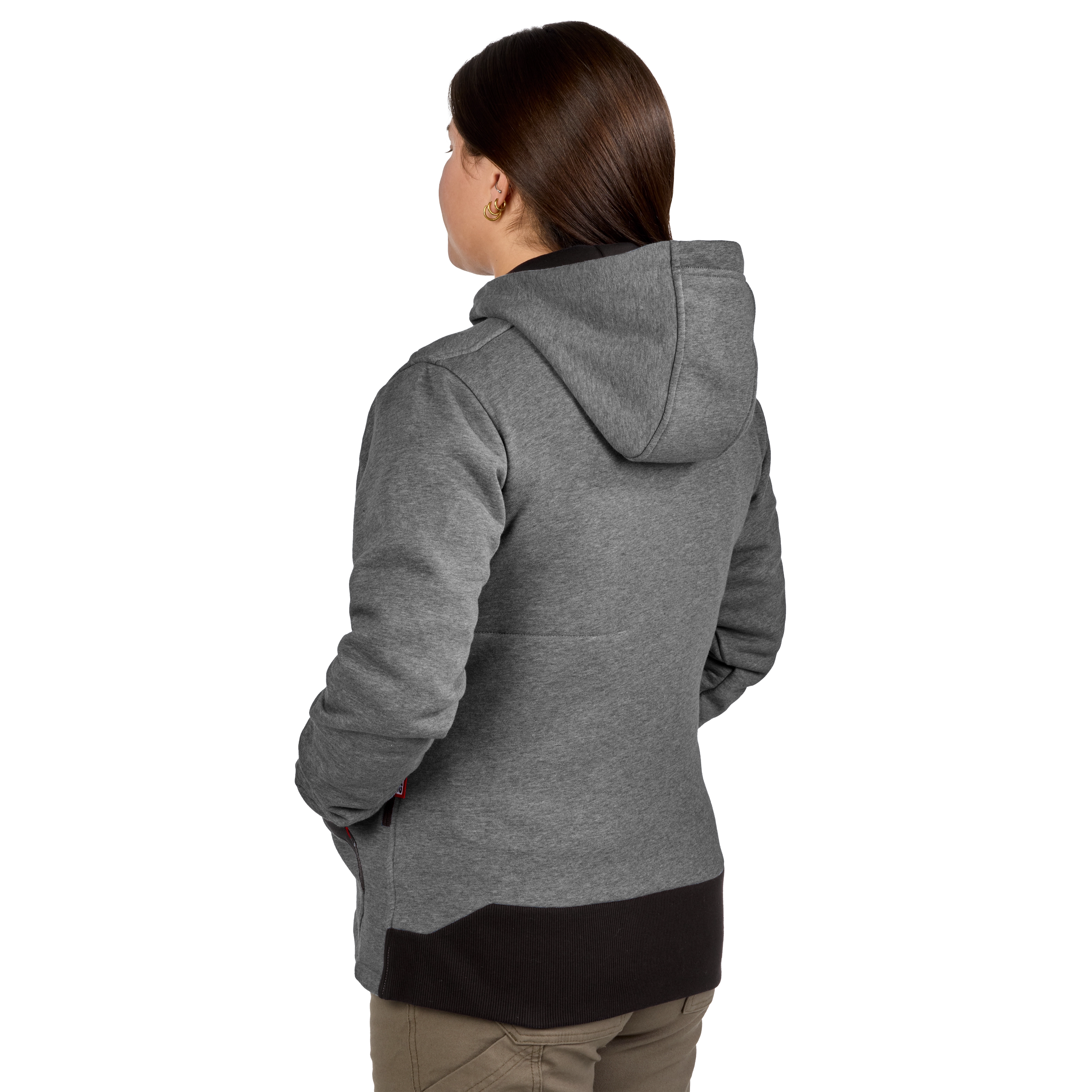 A woman is wearing a gray M12™ Women's Heated Hoodie with a hood. The back view highlights the hoodie’s fabric texture and design. The hoodie ends above her khaki pants.