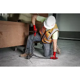 Worker using a 30" Bolt Cutter to cut a metal rod. The worker wears a hard hat, safety vest, jeans, and red gloves.