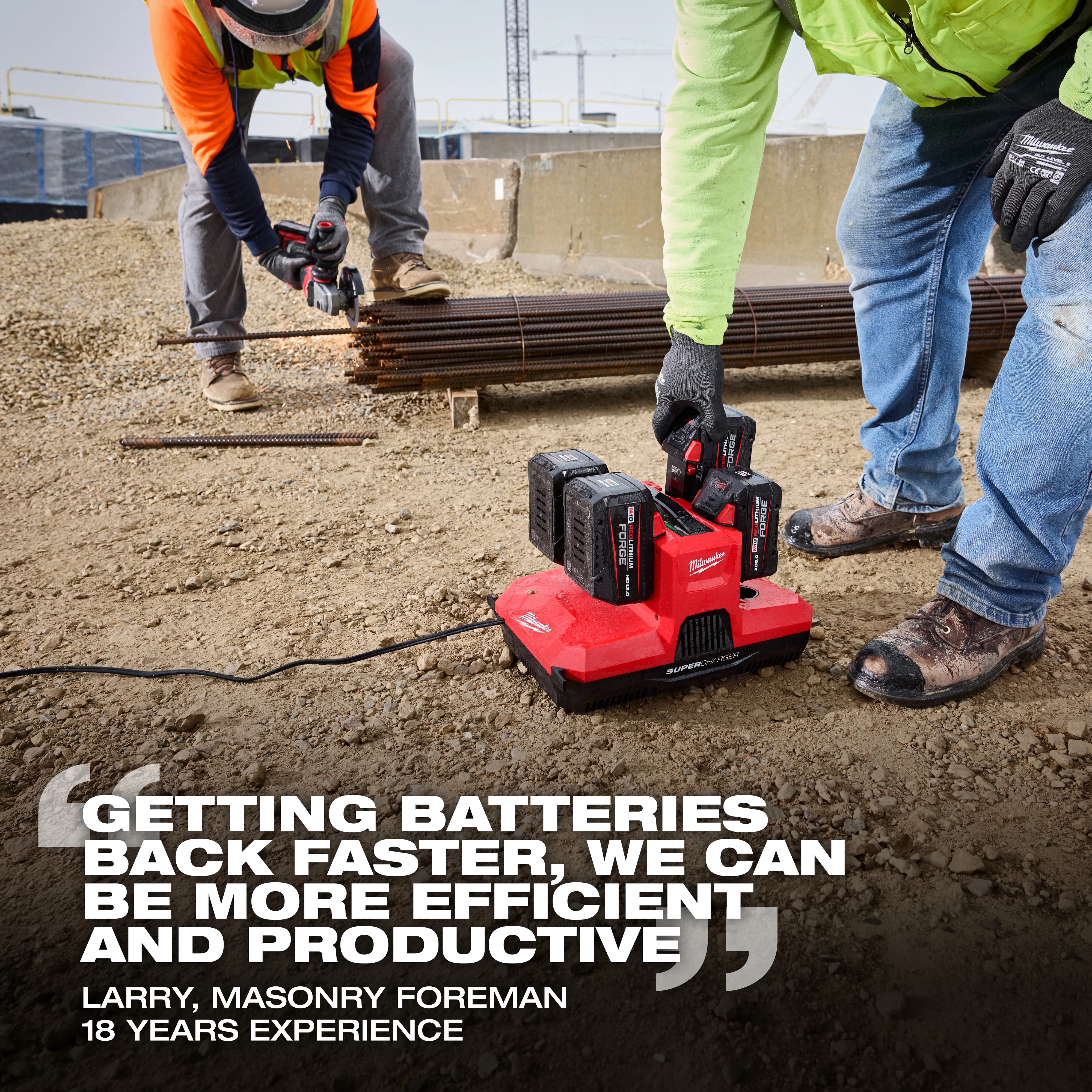 Milwaukee 48-59-1818 M18 and M12 four bay simultaneous super charger powering battery packs on an outdoor construction site near rebar cutting work