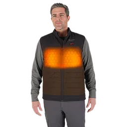 A person is wearing an M12™ Heated AXIS™ Vest over a gray long-sleeve shirt. The vest is highlighted with an orange glow, indicating its heating feature, and features a honeycomb pattern on the heated areas.