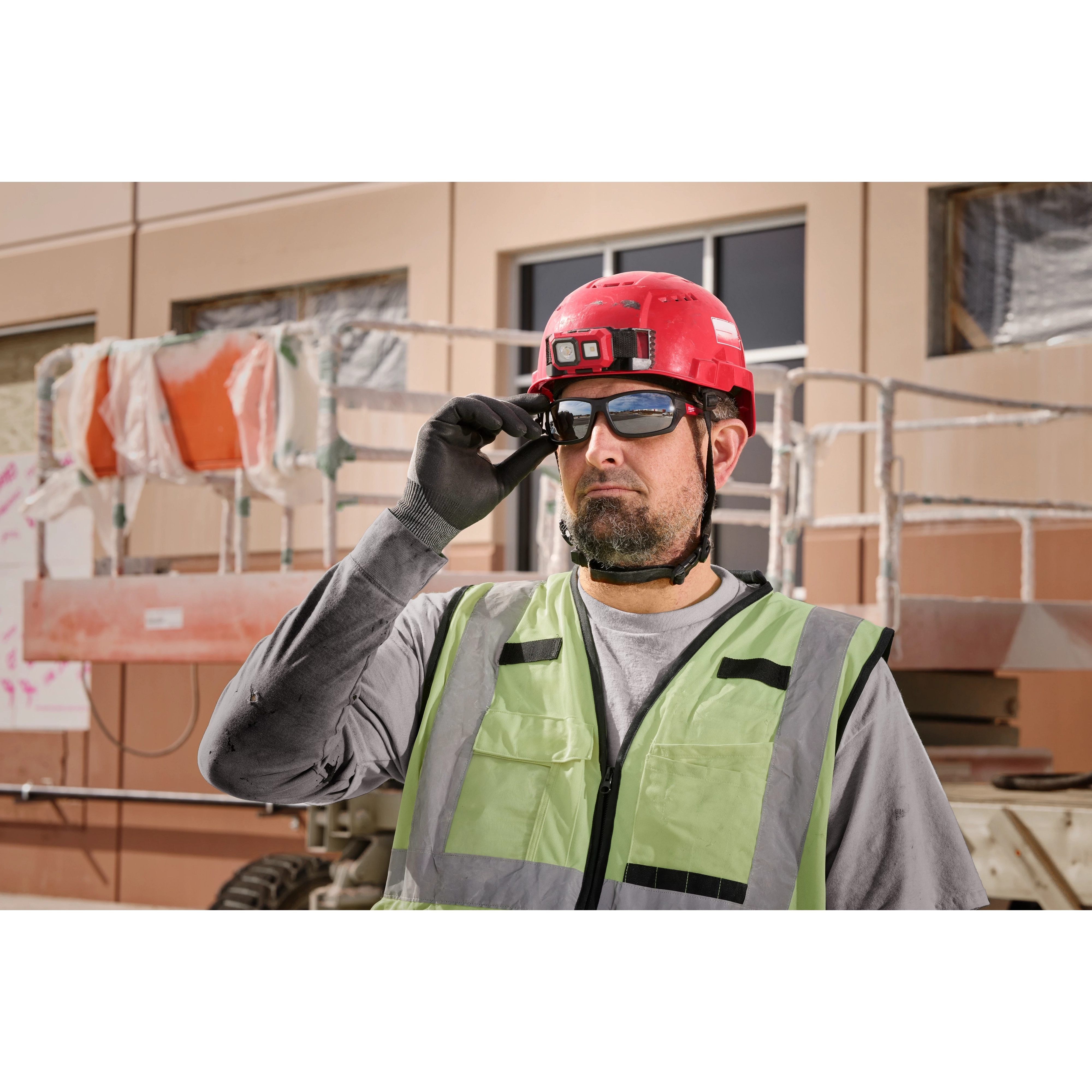 Construction worker wearing Mirrored Performance Safety Glasses - Fog-Free Lenses, a red hard hat, and a reflective vest.