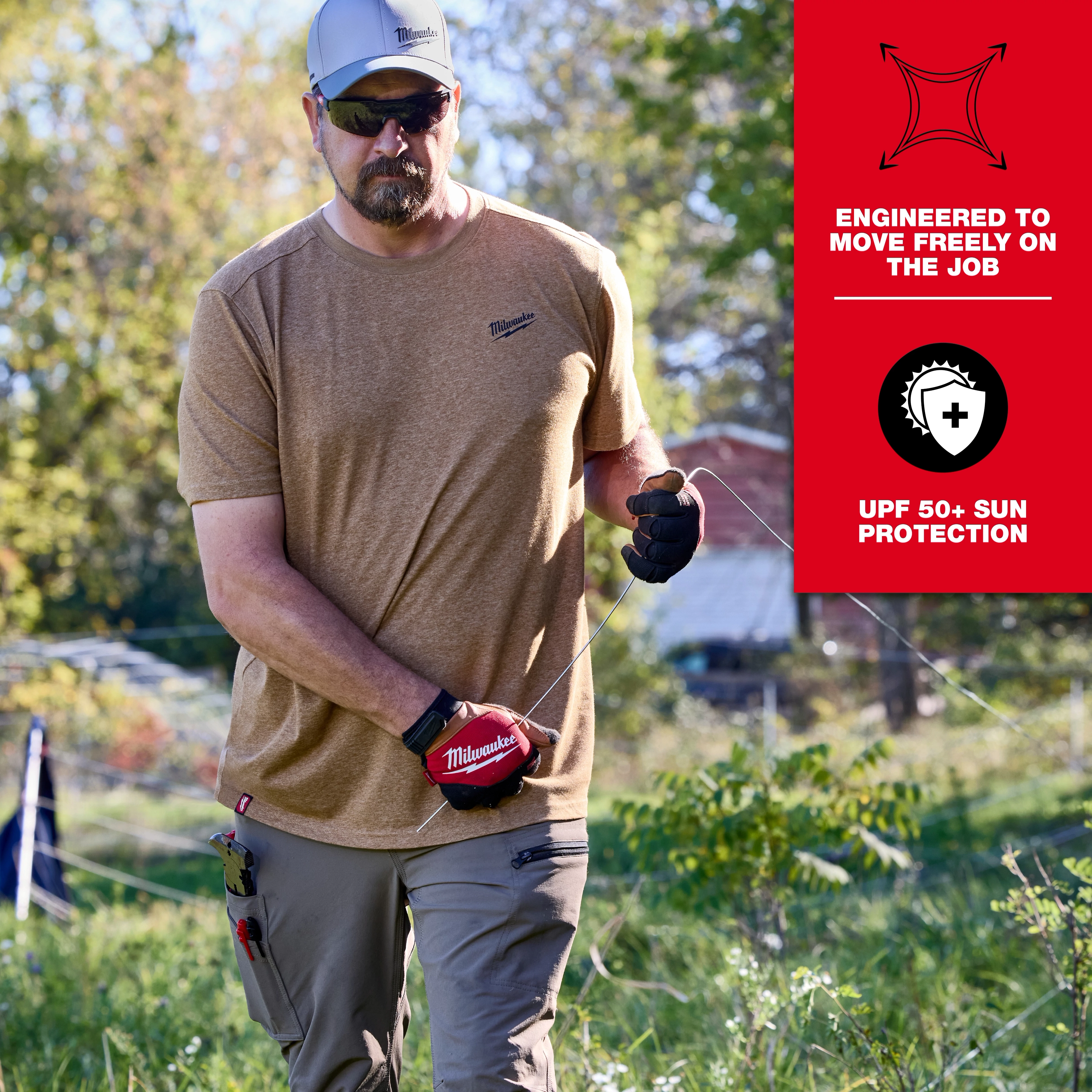 Man wearing a FREEFLEX Hybrid Work Tee - Short Sleeve in a tan color while working outdoors, with UPF 50+ sun protection.