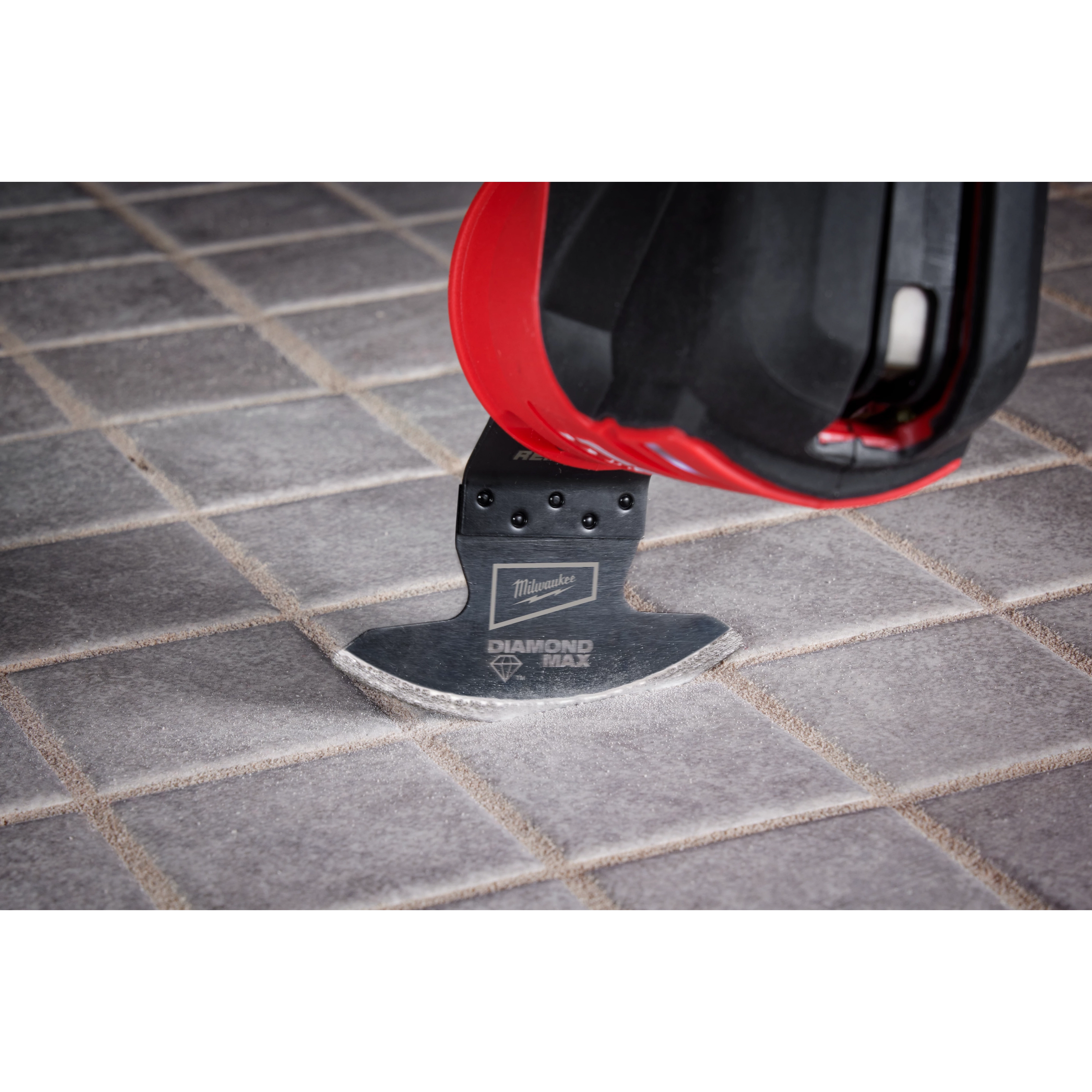 Milwaukee Universal Fit OPEN-LOK Diamond MAX Diamond Grit Grout Removal Multi-Tool Blade in use on a tiled floor.