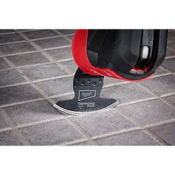 Milwaukee Universal Fit OPEN-LOK Diamond MAX Diamond Grit Grout Removal Multi-Tool Blade in use on a tiled floor.