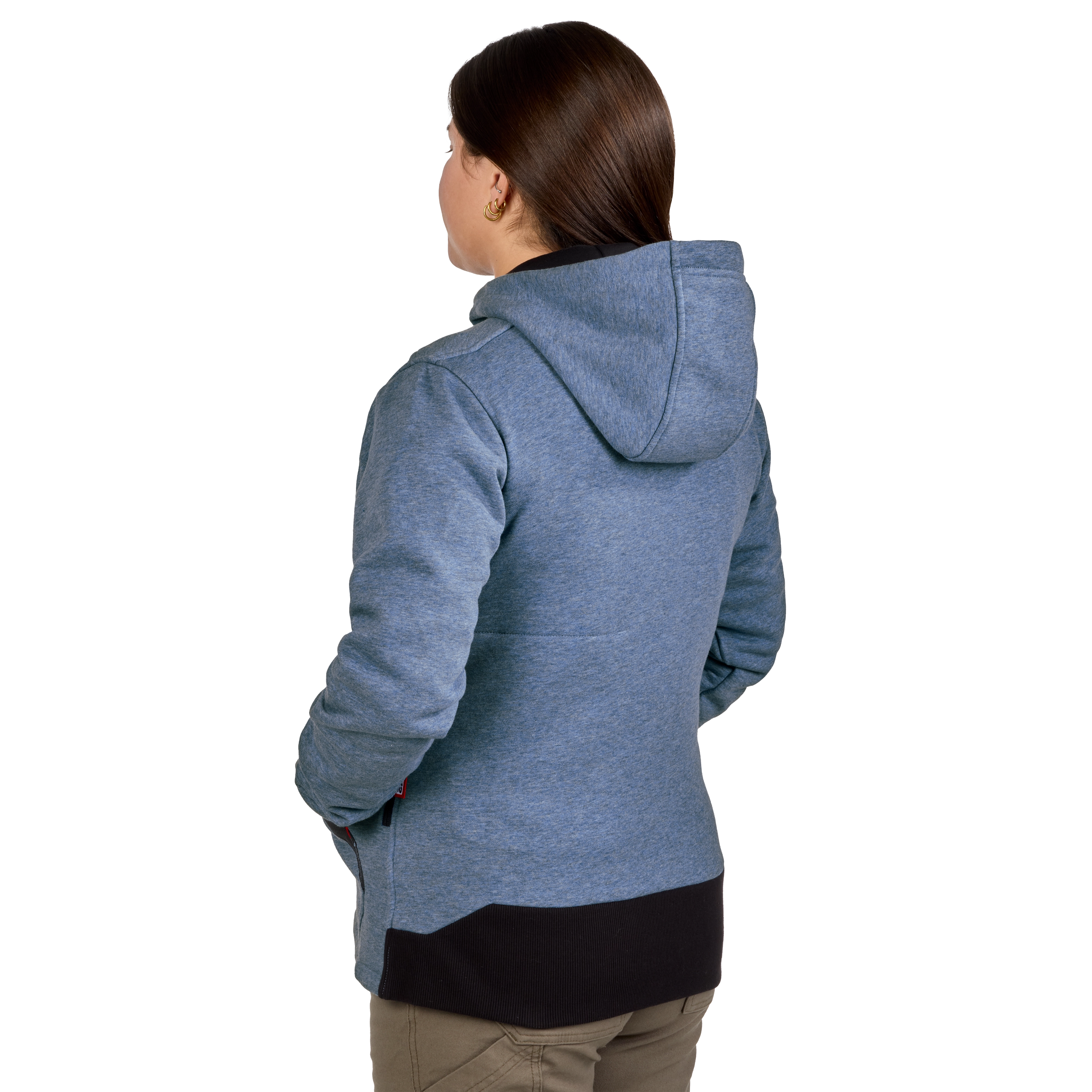 A woman is wearing a gray M12™ Women's Heated Hoodie with a hood. The jacket features a black section on the bottom hem and is worn with khaki pants.