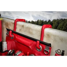 2" Bucket Hooks in red are mounted on the rim of a white surface, holding a red tool apron with various tools and accessories.