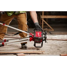 Worker securely holding the Red Exterior Rotary Laser Level by the attached handles