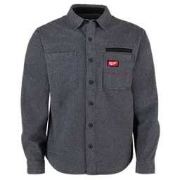 The GRIDIRON Flannel Shirt is a dark grey, long-sleeve, button-up shirt featuring two chest pockets. One pocket has a black trim and red logo patch. It has a classic collar, button placket, and adjustable cuffs. This durable shirt provides comfort and style for on-the-job wear.