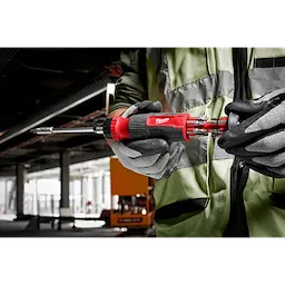 Person wearing gloves and a safety vest holds a 14-in-1 Ratcheting Multi-Bit Screwdriver with interchangeable bits displayed.