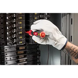 A gloved hand uses the 2-in-1 1000V Insulated Flip Shank Multi-Bit Screwdriver to adjust a switch inside an electrical panel.