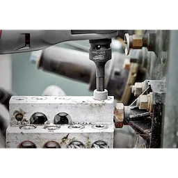 Shockwave Lineman's 6PT 9/16" x 3/4" 2-in-1 Socket attached to a power tool, screwing a bolt into an electrical terminal block.