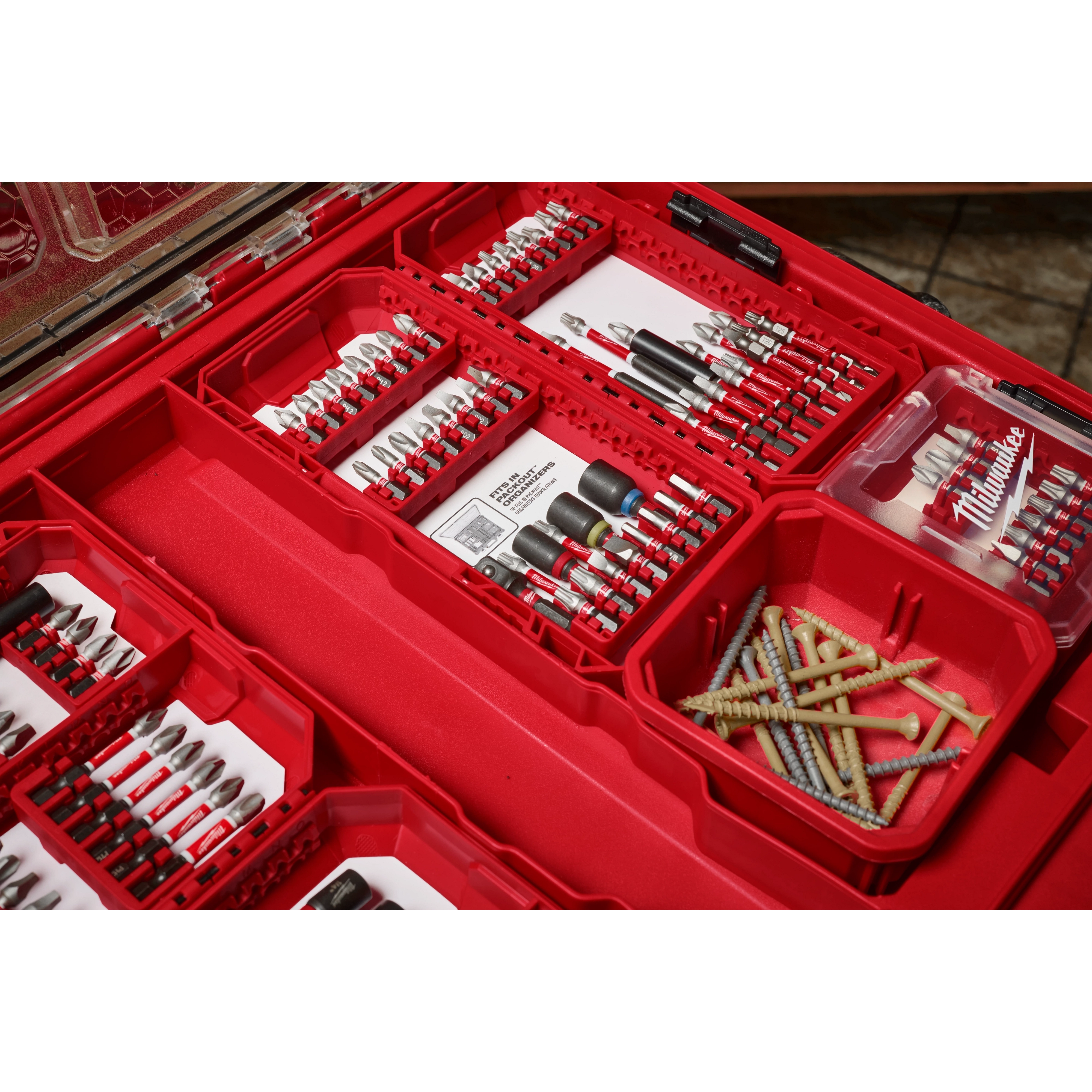 The image shows the SHOCKWAVE™ Impact Duty™ Driver Bit Set - 54PC, neatly organized in a red plastic case. The set includes various drill bits, including Phillips, slotted, and hex bits, along with several long screws housed in a separate compartment within the case.