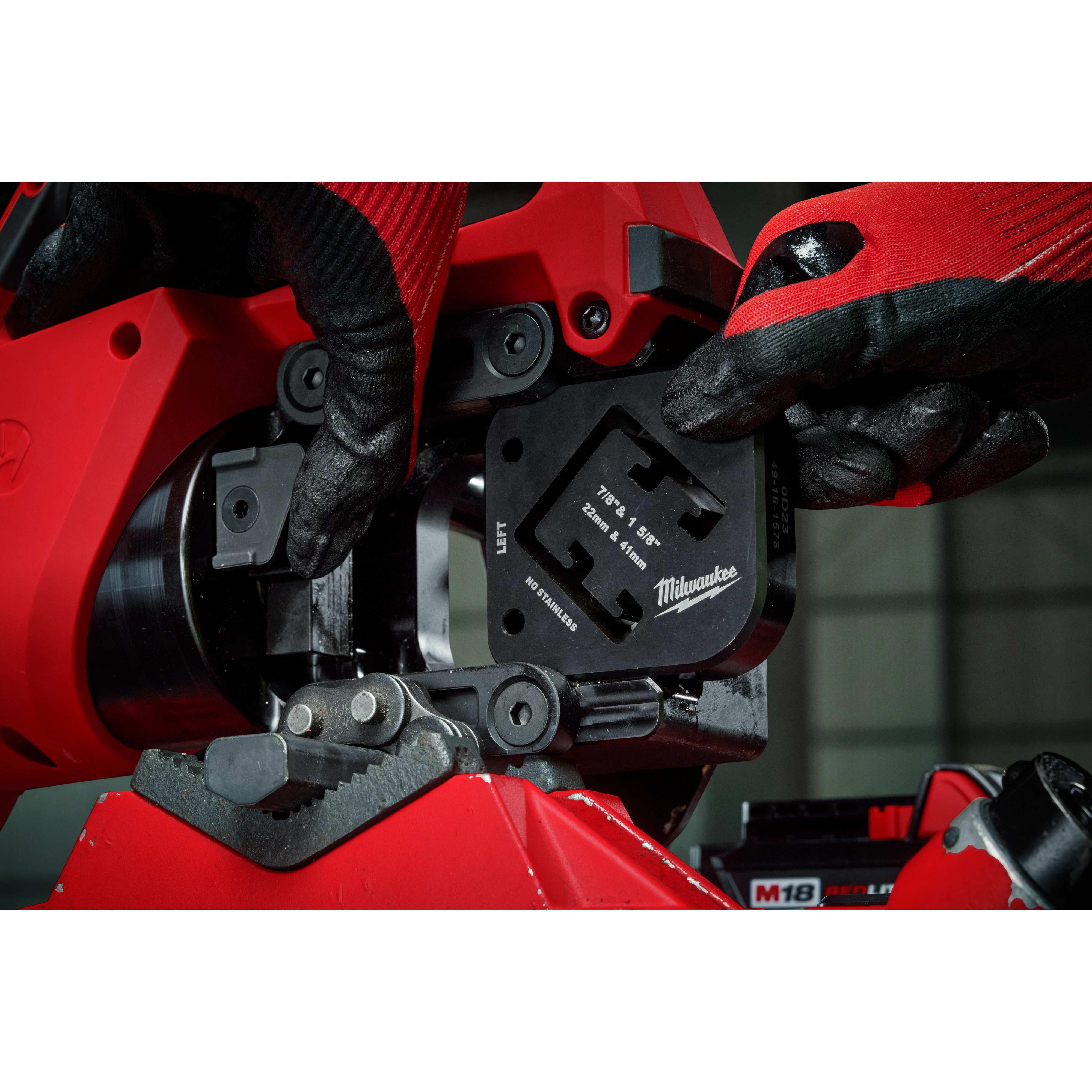 Close-up of hands installing a 7/8" & 1-5/8" x 1-5/8" Combination Strut Shearing Dies in a red power tool.