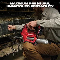 A person using a red Milwaukee cordless grease gun on heavy machinery tracks. The text above reads, "MAXIMUM PRESSURE, UNMATCHED VERSATILITY." The grease gun has a flexible hose and metal barrel, conveying its robust performance.