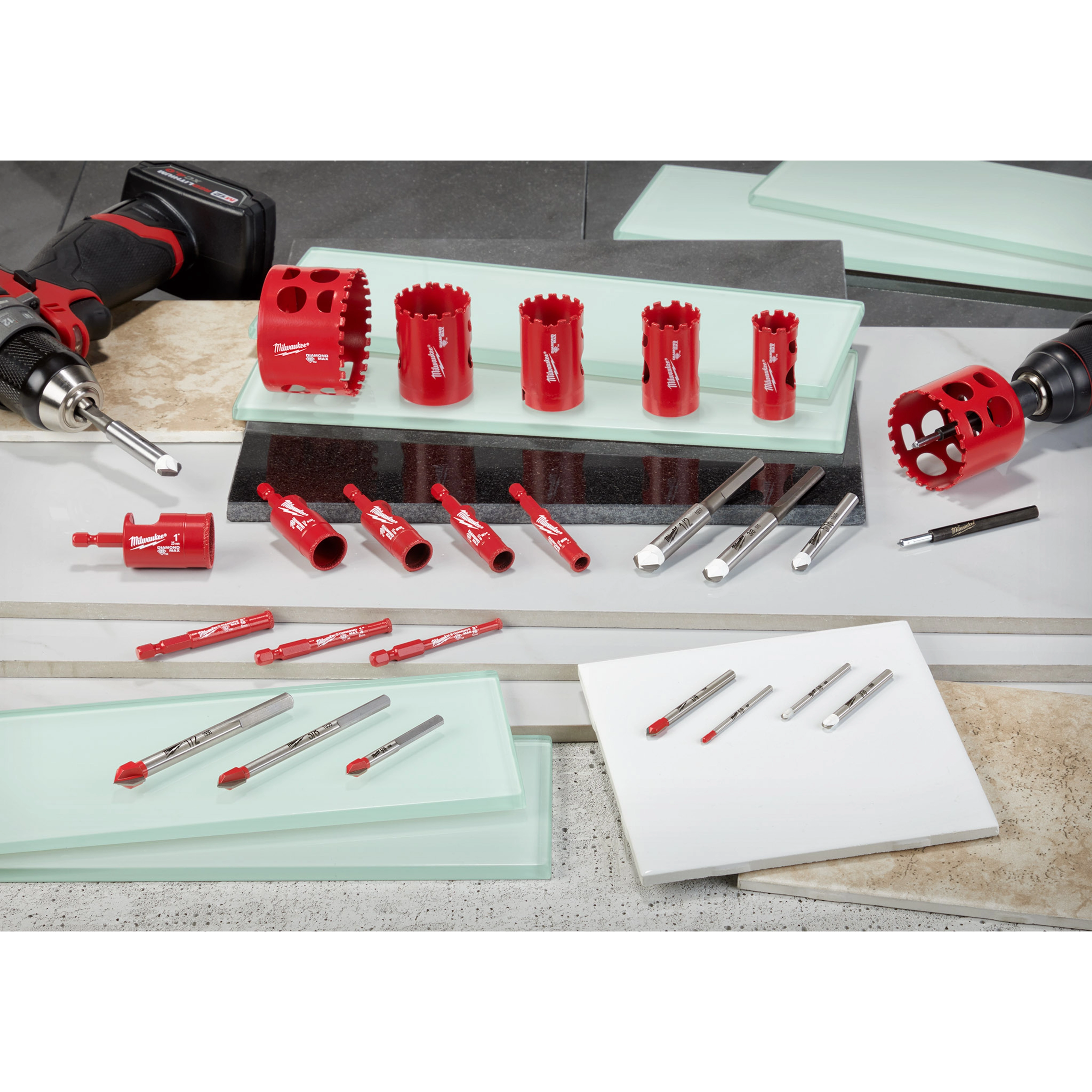 2020 Glass and Tile Accessories Family Shot features red drill bits, hole saws, and accessories arranged on tiles and glass surfaces.