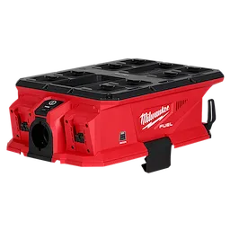 This image shows the Milwaukee M18 FUEL PACKOUT Six Bay Rapid Charger, a red and black rectangular device designed to charge up to six batteries simultaneously. The charger features branded logos and multiple docking slots for batteries. It is rugged and designed for professional use.