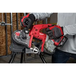 Person using a red and black Compact Thick Metal Band Saw Blade to cut metal pipe, wearing red and black gloves.