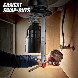 A Milwaukee Spanner Wrench is being used to install or remove a garbage disposal unit under a sink. The text "Easiest Swap-Outs" is displayed at the top left corner.