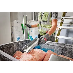 Person wearing Cut Level 4 High-Dexterity Nitrile Dipped Gloves - XL while handling construction materials in a workshop.