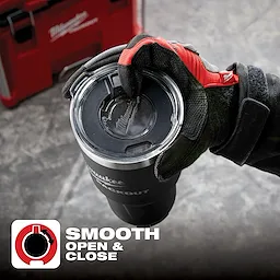 App%20Shot%20Overlay shows a gloved hand holding a black insulated tumbler with a smooth open and close lid, against a workshop background.