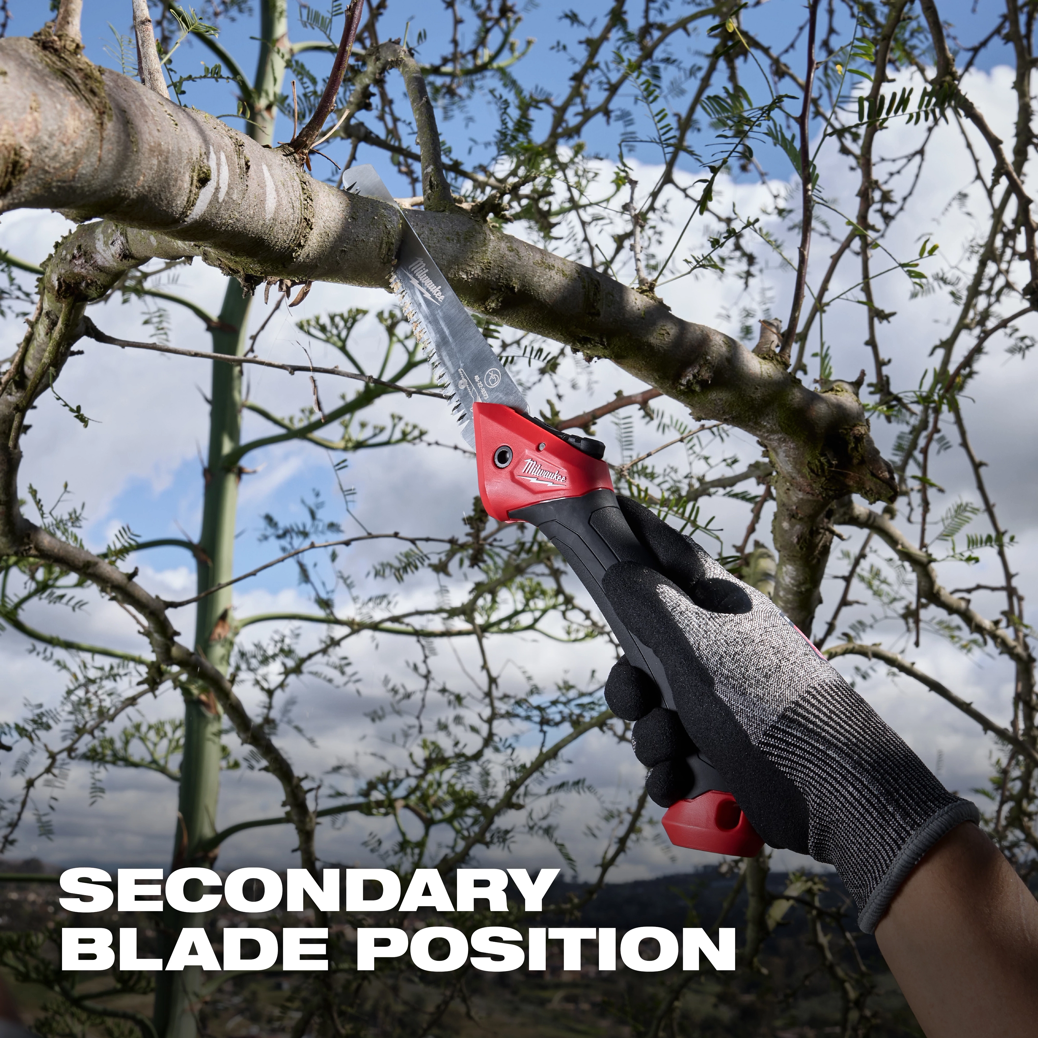 7” Folding Pruning Saw – Straight Blade cutting a tree branch, held by a gloved hand outdoors.