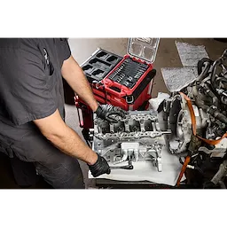 Mechanic using the 41pc 1/4” and 3/8” Drive Metric Bit Socket Set with PACKOUT Compact Low-Profile Organizer on an engine.