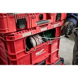 Red PACKOUT Wire Pulling XL Crate holding multiple spools of wire. A gloved hand is pulling a wire from the crate.