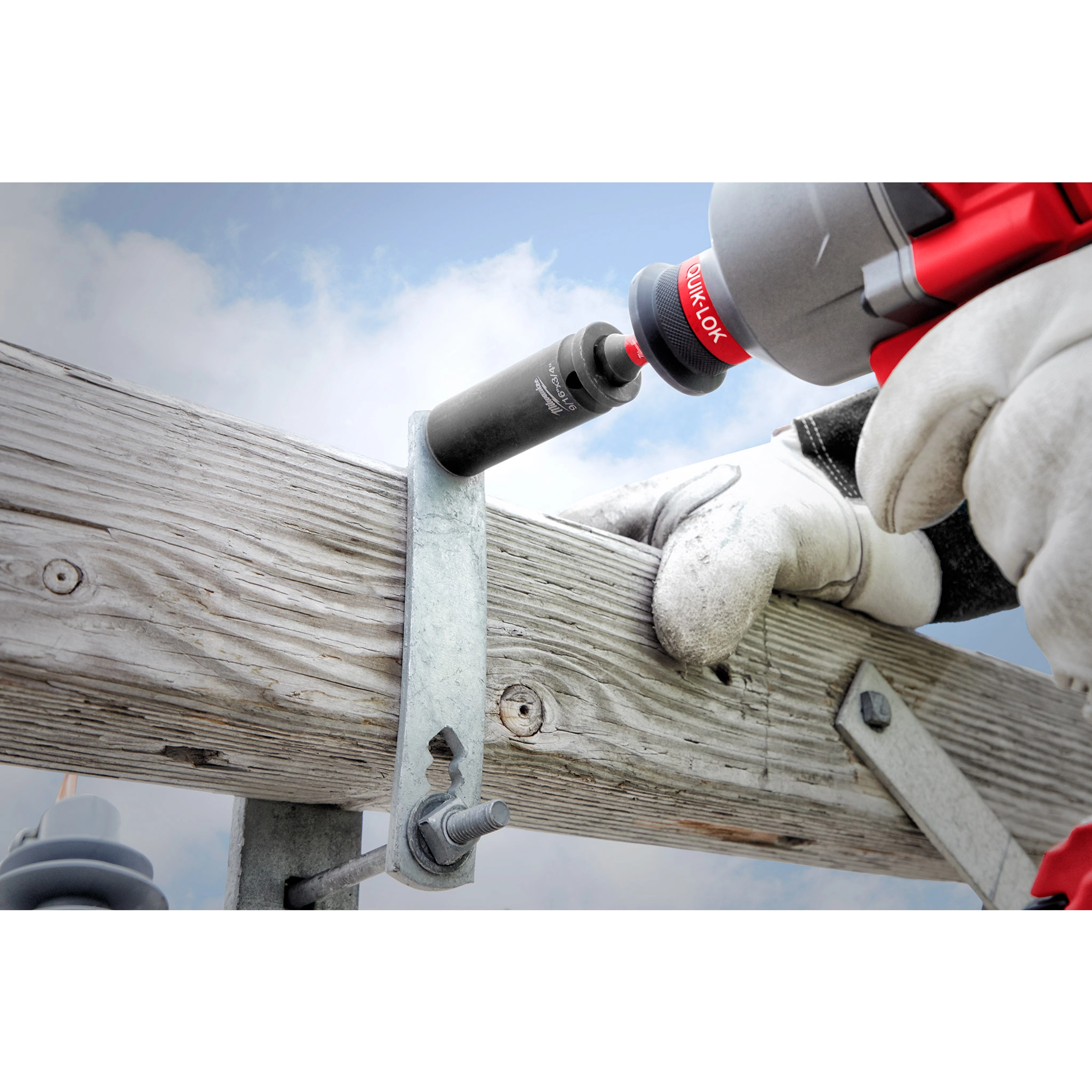 Worker using a 9/16"-3/4" 12PT 2-in-1 Socket to tighten a bolt on a metal bracket attached to a wooden post.