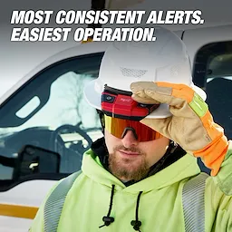 Worker in safety gear holding a BOLT Personal Voltage Detector in front of a utility vehicle.
