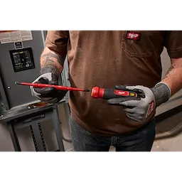 A person wearing gloves holds a 2-in-1 1000V Insulated Flip Shank Multi-Bit Screwdriver near an electrical panel, highlighting its flip shank feature.