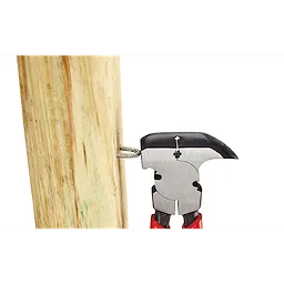 The Comfort Grip Fencing Pliers are gripping a nail embedded in a wooden post. The pliers have red handles and a metal head designed for pulling nails and cutting wire.