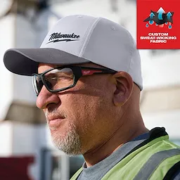 Gray WORKSKIN Performance Fitted Hat with custom sweat-wicking fabric. The hat is worn outdoors on a sunny day.