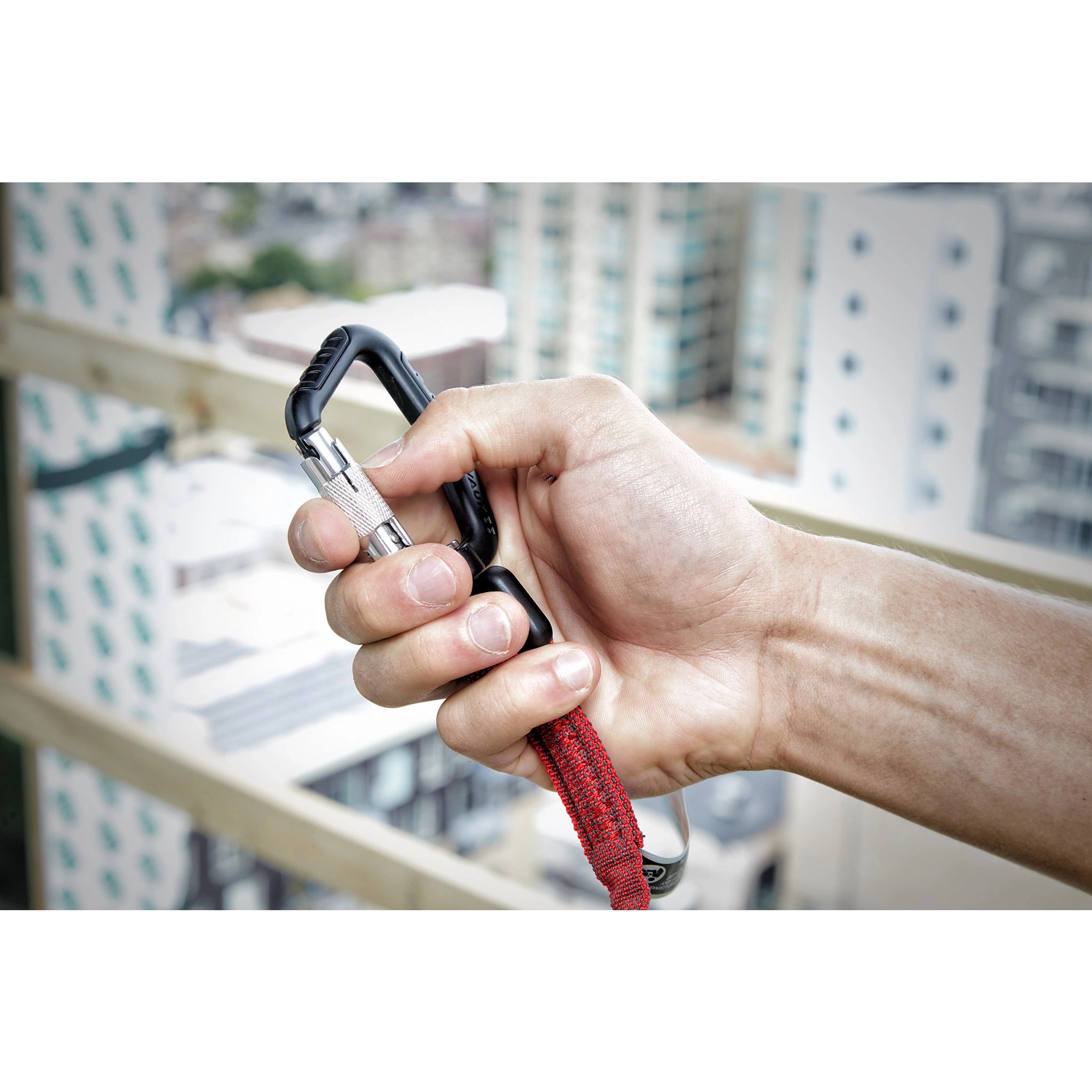 10LBS 72" Extended Reach Locking Tool Lanyard held by a man's hand with a view of city buildings in the background.