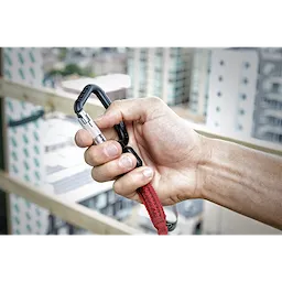 10LBS 72" Extended Reach Locking Tool Lanyard held by a man's hand with a view of city buildings in the background.