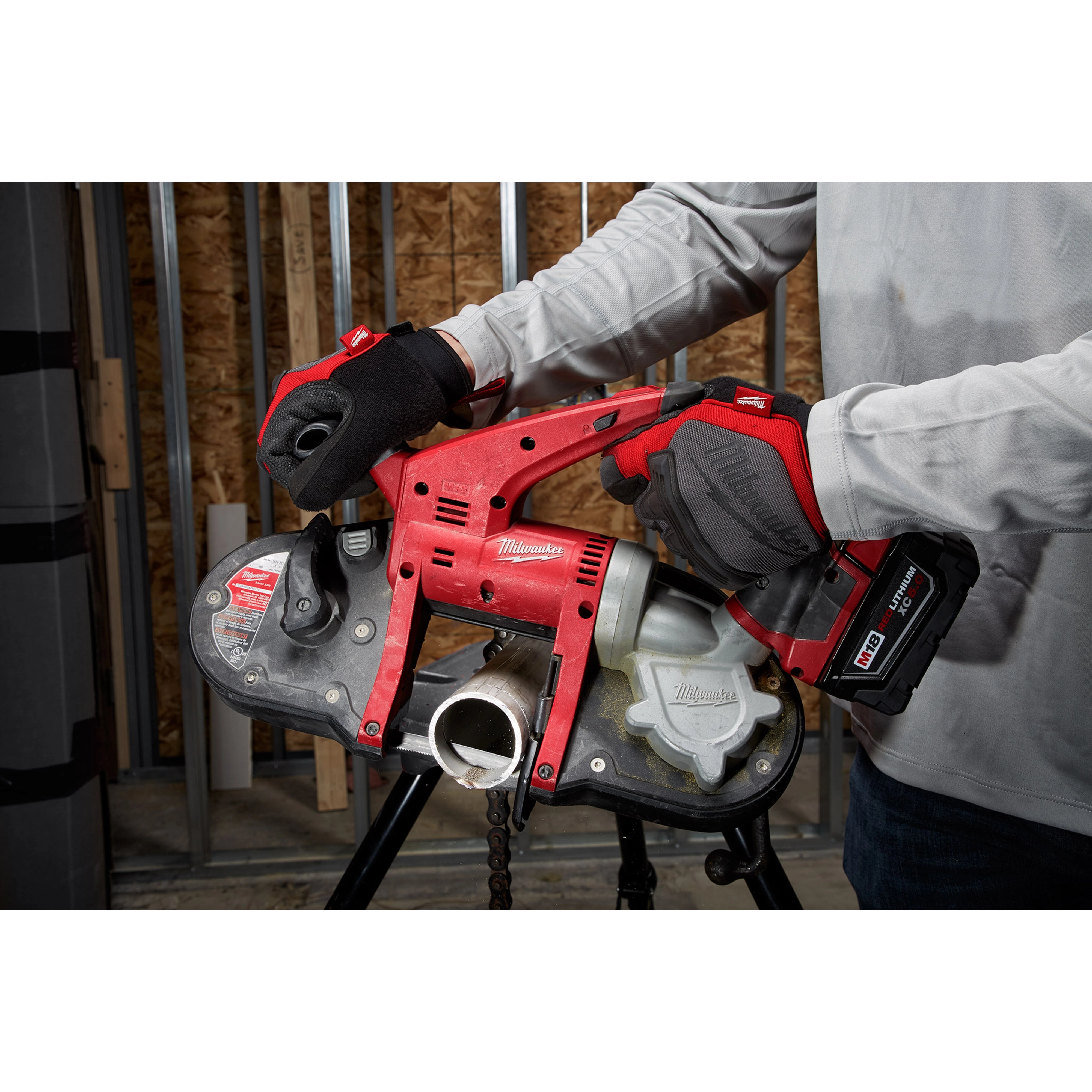 A person using the Compact Extreme Thin Band Saw Blade to cut a metal pipe, with a red and black handheld power tool.