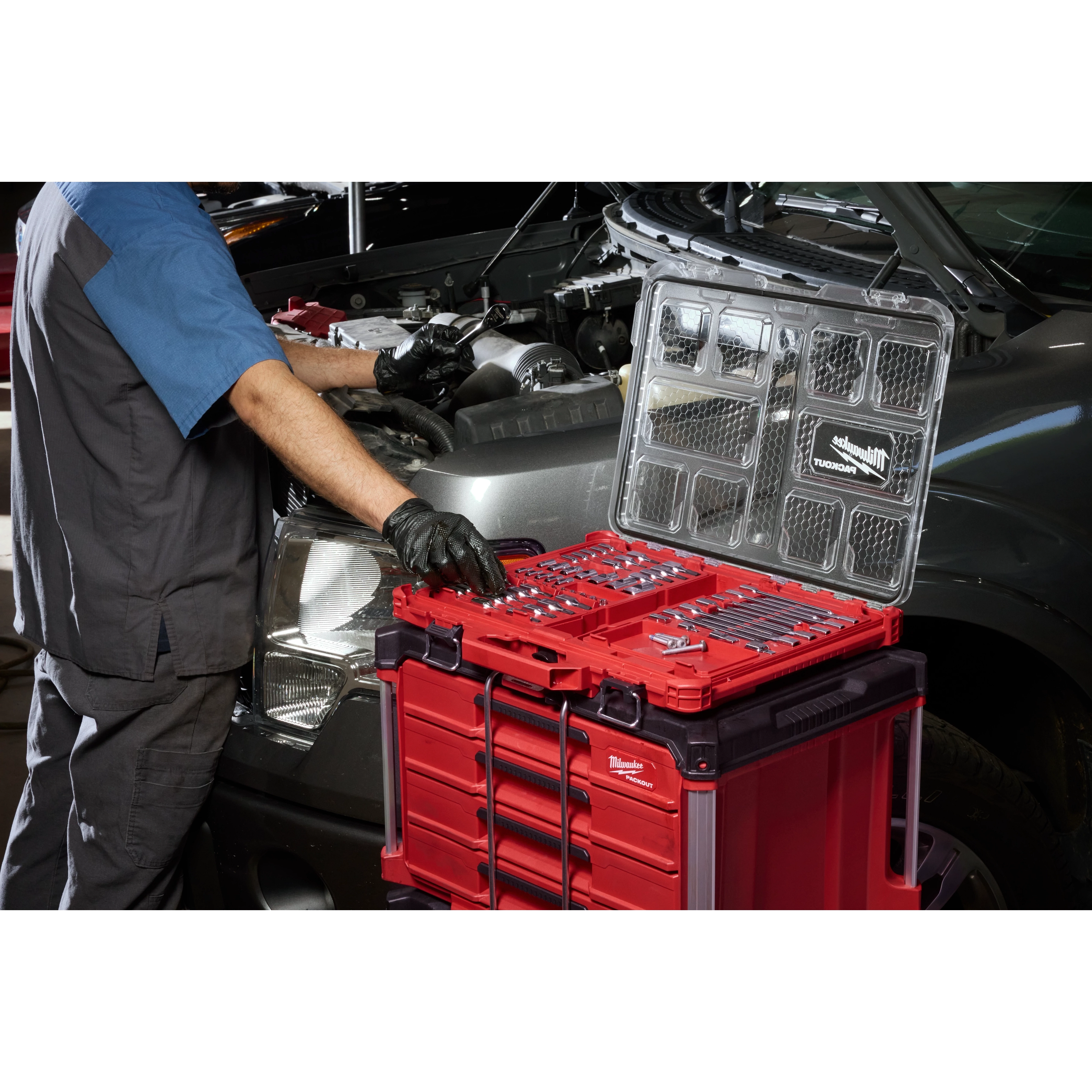 Mechanic using 67pc 1/4”, 3/8”, and 1/2” Drive TORX Bit Socket Set with PACKOUT Low-Profile Organizer beside a car.