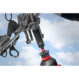 9/16"-3/4" 12PT 2-in-1 Socket connected to a power tool, tightening bolts on a mechanical component against a blue sky background.