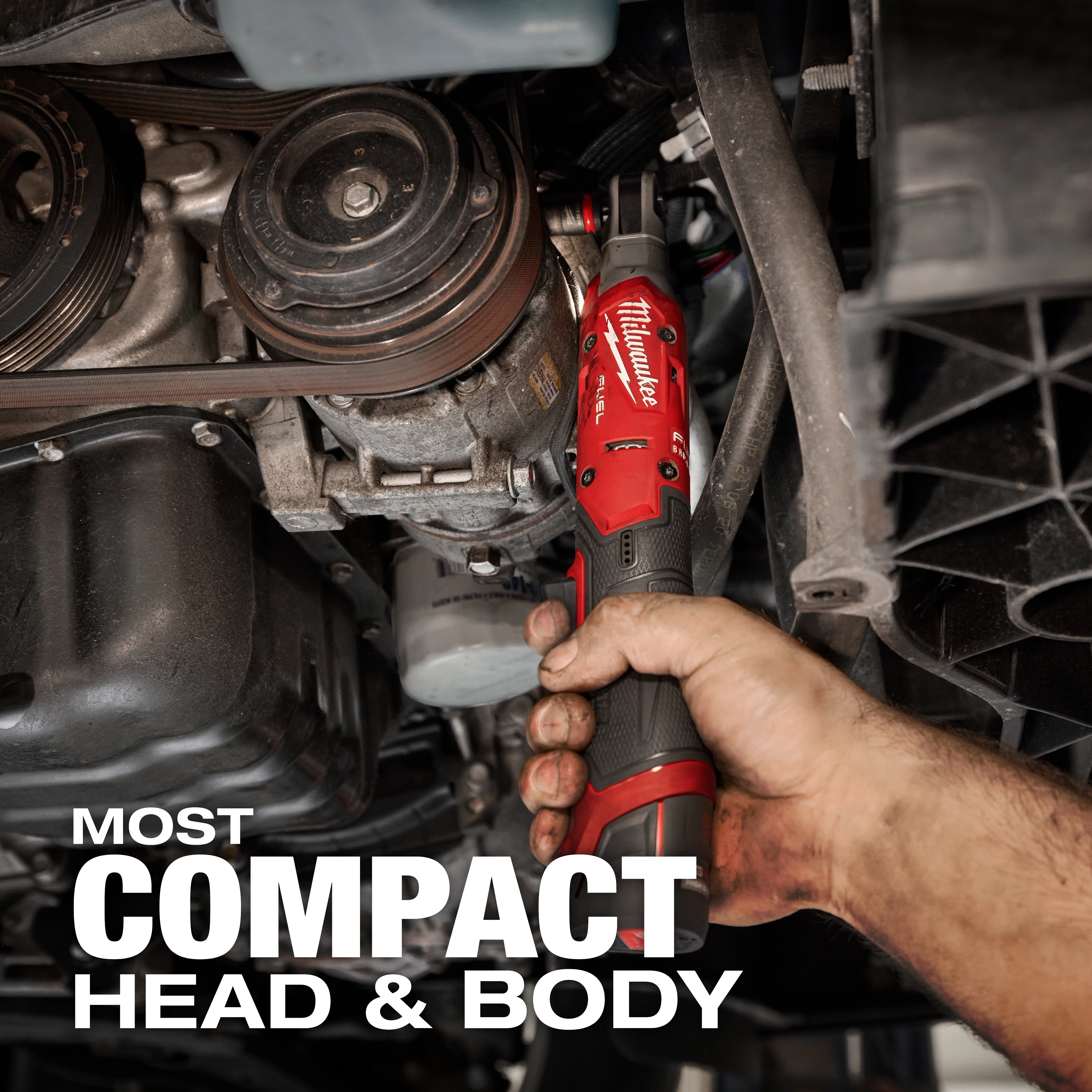 A person is using the M12 FUEL™ 3/8" Ratchet to work on a car engine. The ratchet's red and black design is visible, showing its compact size suitable for tight spaces. Text in the image reads "MOST COMPACT HEAD & BODY."