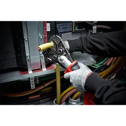 A person uses the 750%20MCM%20Cu%2FAl%20Cutting%20Jaw to cut a thick yellow electric cable inside an industrial setting.