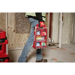 Worker carrying the 79PC Class A Type III PACKOUT™First Aid Kit  by its handle on the jobsite