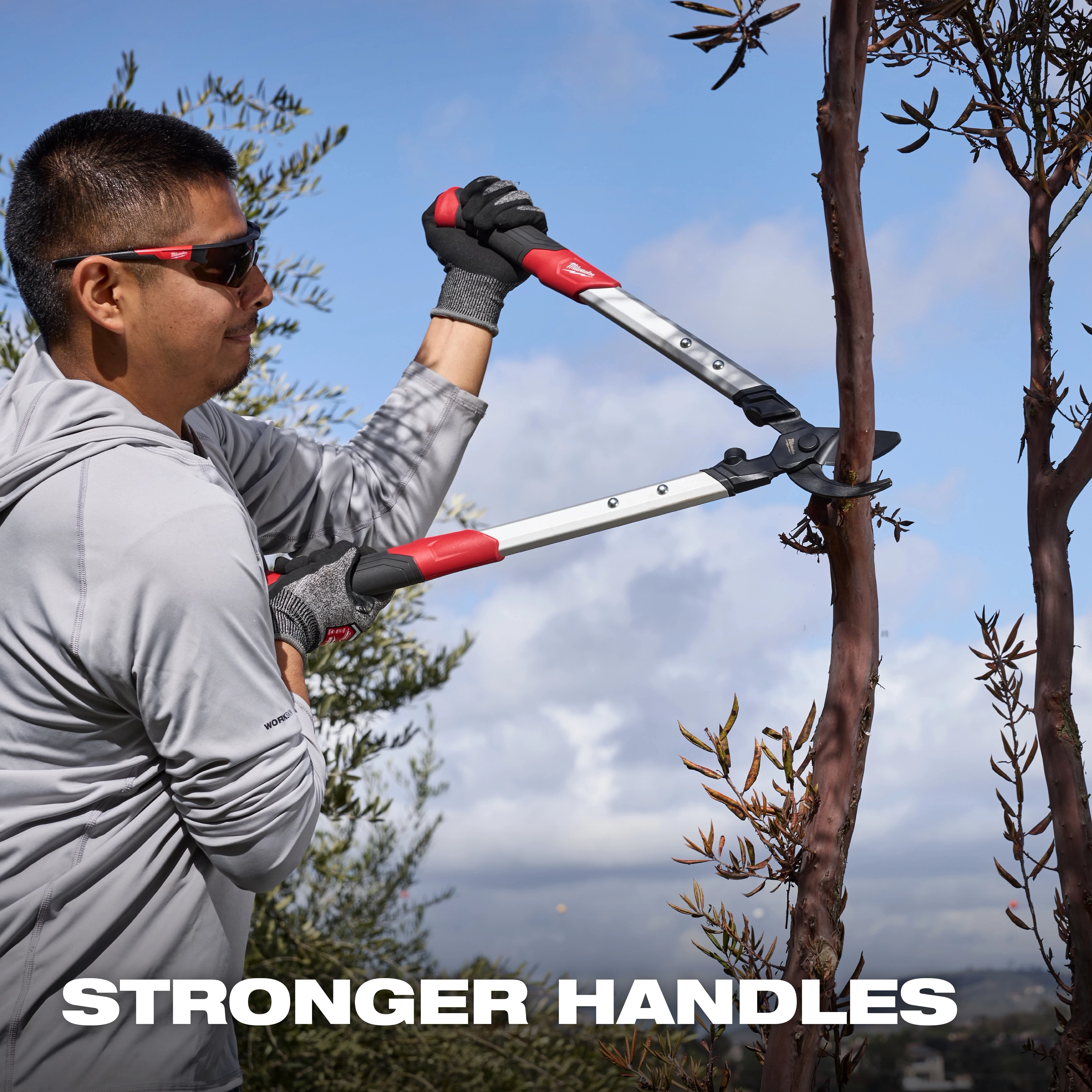 Person using a 1-1/2” Lopper​ to cut a tree branch outdoors, with text reading STRONGER HANDLES.