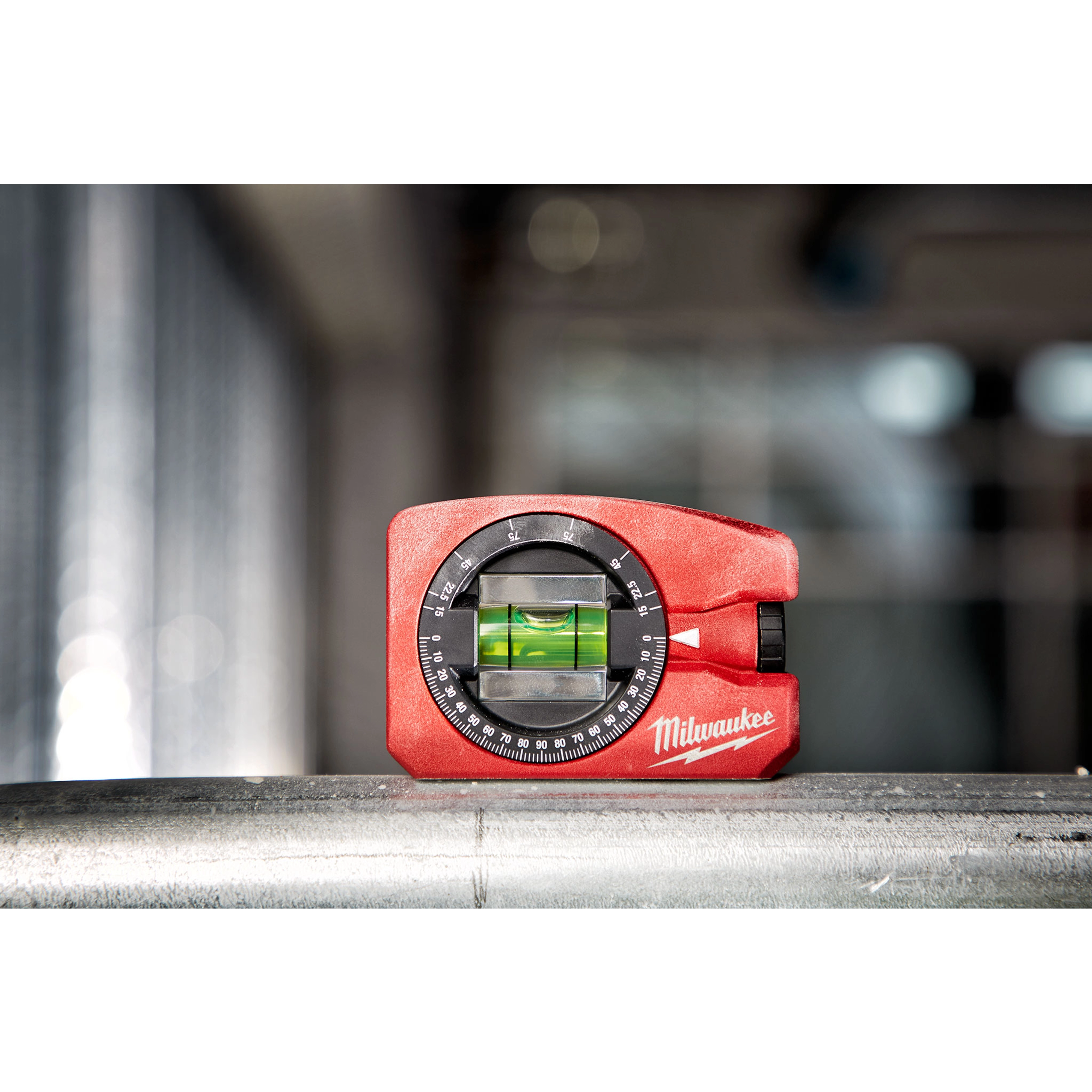 Milwaukee Pocket Level is a compact red leveling tool with a clear vial and adjustable dial, placed on a metallic surface.