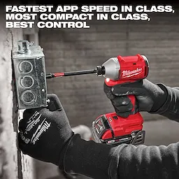 A person wearing gloves uses a red Milwaukee cordless impact driver to install a metal electrical box. The text above says, "Fastest app speed in class, most compact in class, best control." The tool is part of the M18 4-Tool Combo Kit.