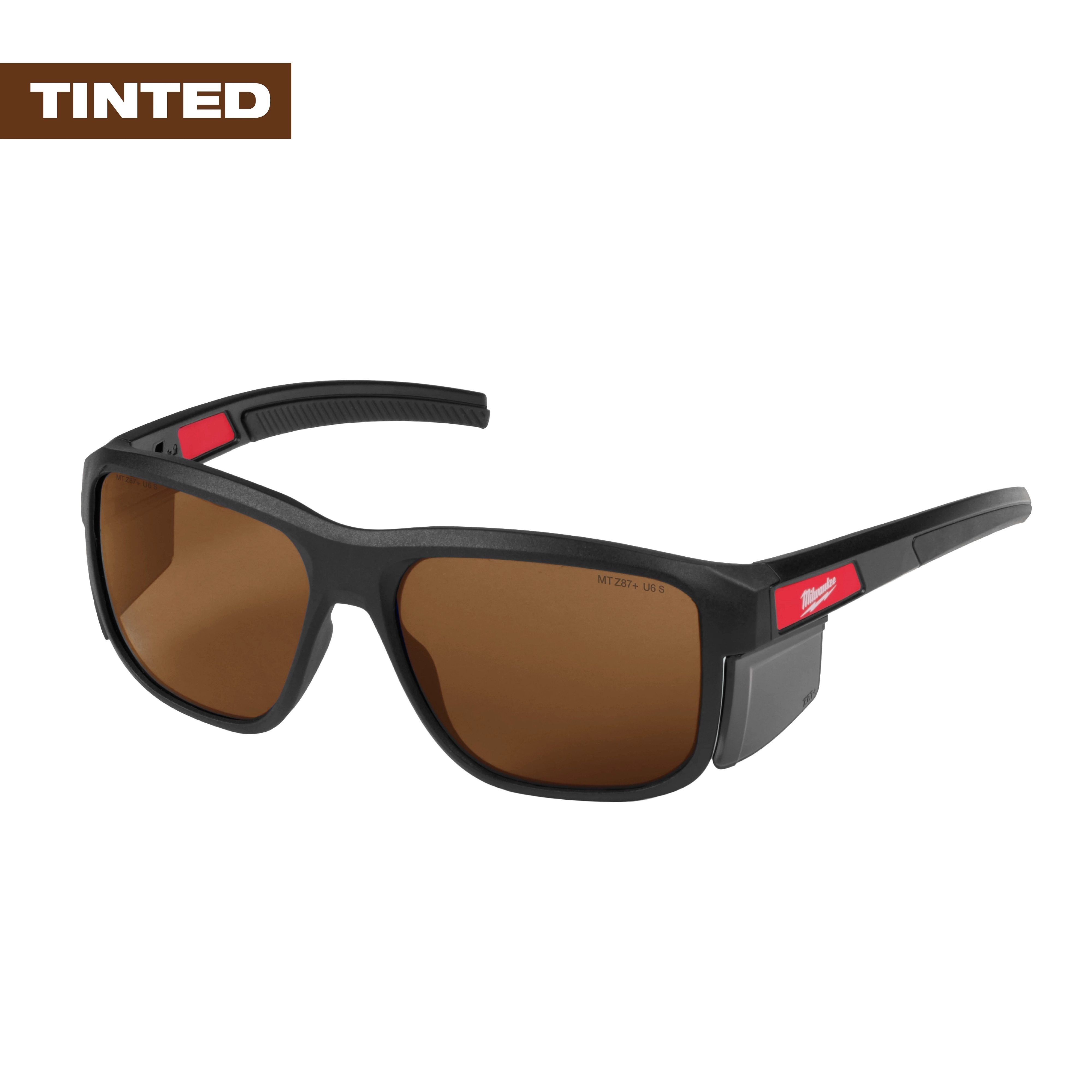 The Milwaukee tinted safety glasses feature a black frame with brown lenses and red accents on the arms. They are designed for eye protection while working under bright conditions with removable side shields.