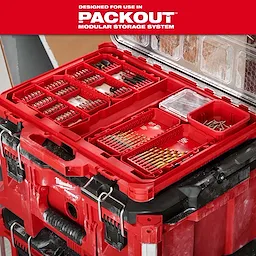 The image features a red storage system designed for use in PACKOUT Modular Storage System. It contains organized compartments with various drill bits, screws, and fasteners. The case sits atop another PACKOUT unit and includes clear plastic lids for visibility and protection of contents.
