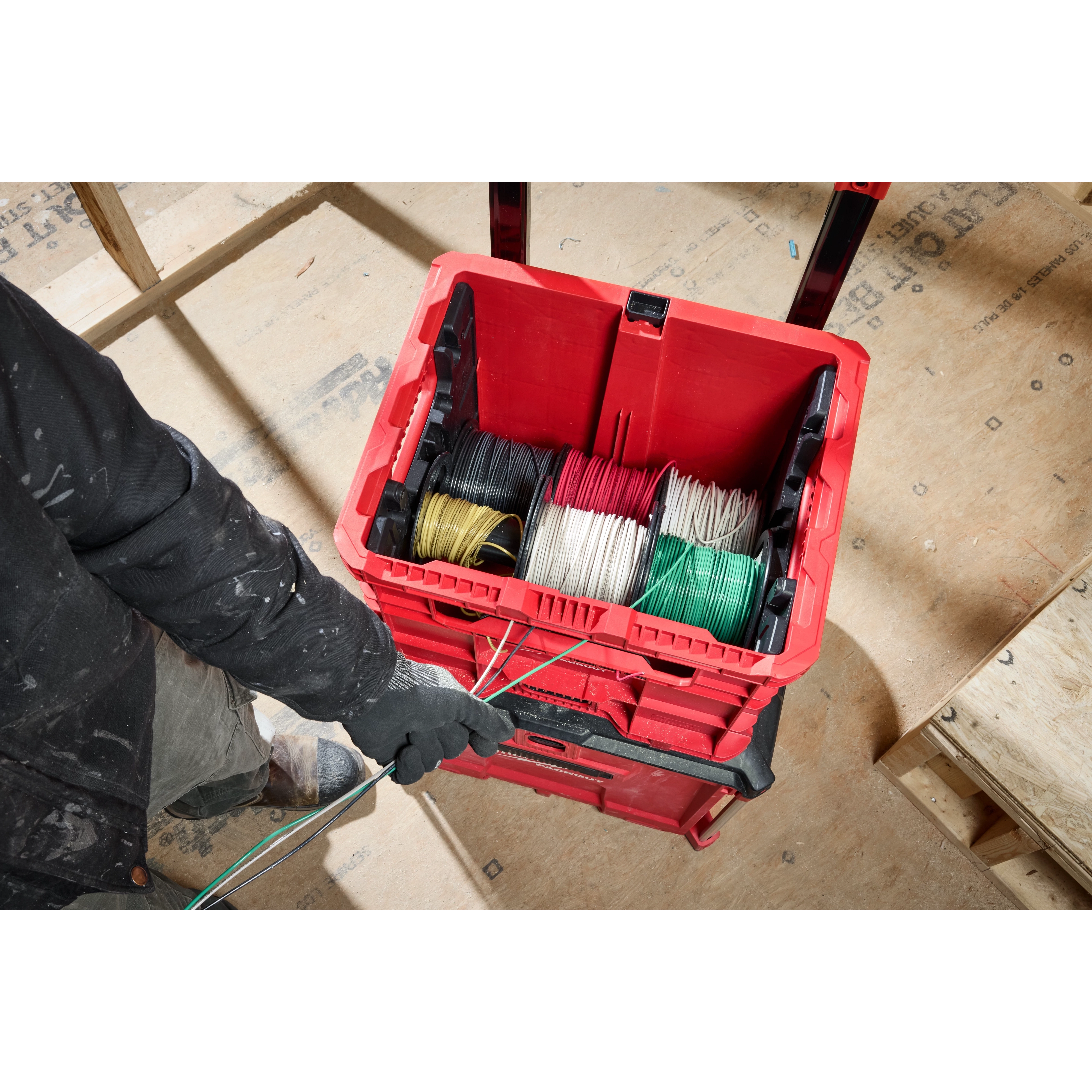 PACKOUT Wire Pulling XL Crate containing neatly organized spools of wire in various colors. A person is pulling wires from the crate.