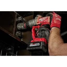 A person uses the SHOCKWAVE™ Impact Duty™ 1’’ Drive 1-5/8’’ Deep 6 Point Socket with a red power tool to tighten bolts on a metal structure. The person's hands are wearing red and black gloves.